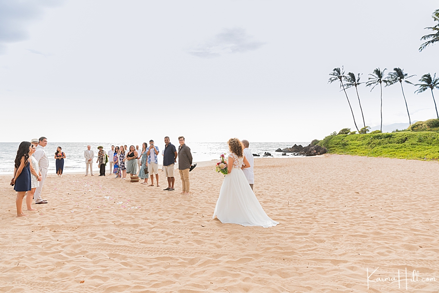 bride walks down the aisle on the beach 