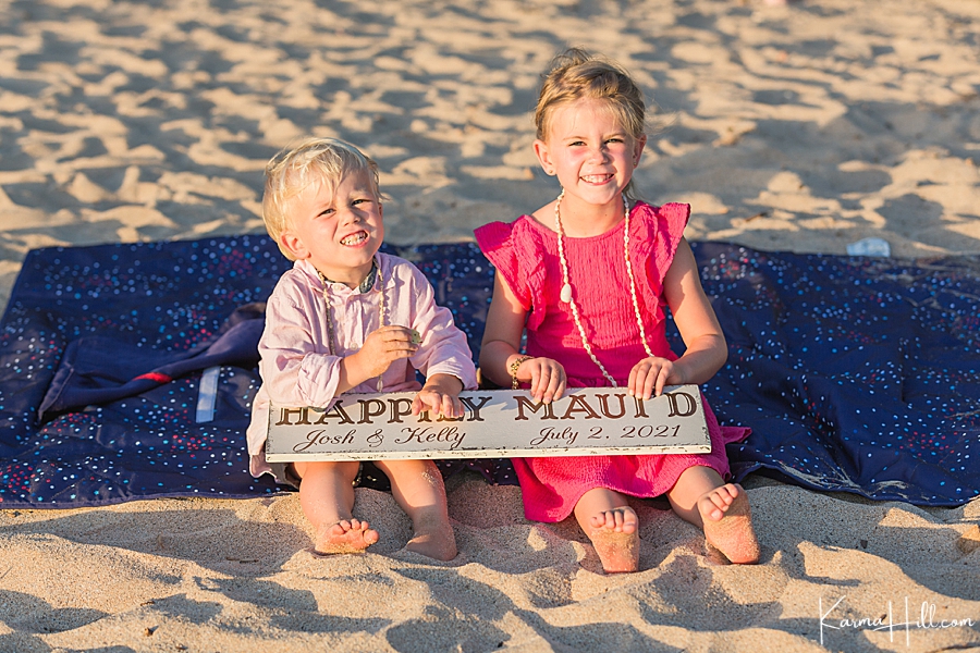 adorable kids hold a wedding sign during their parents beach wedding 
