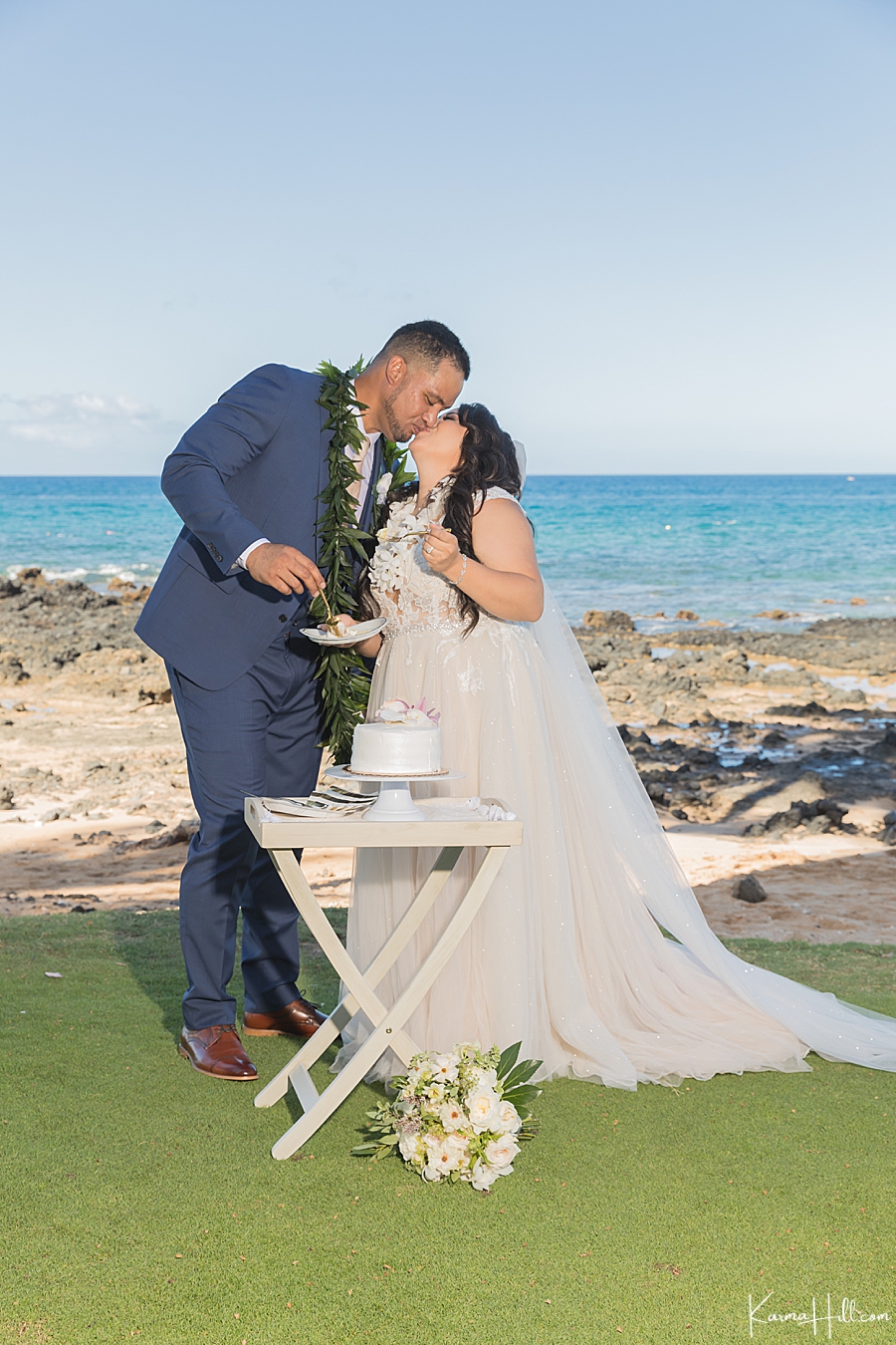 bride and groom kiss with wedding cake