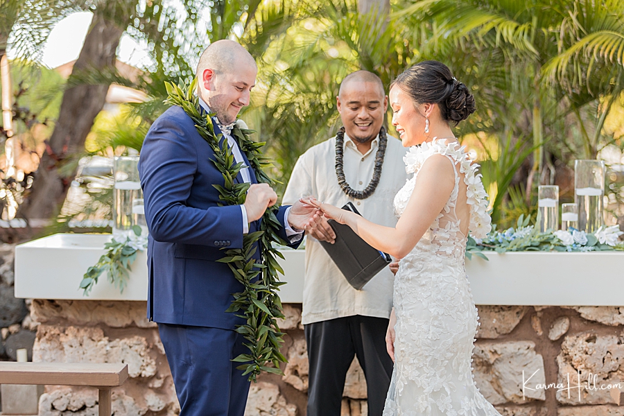 groom putting ring on bride at maui wedding