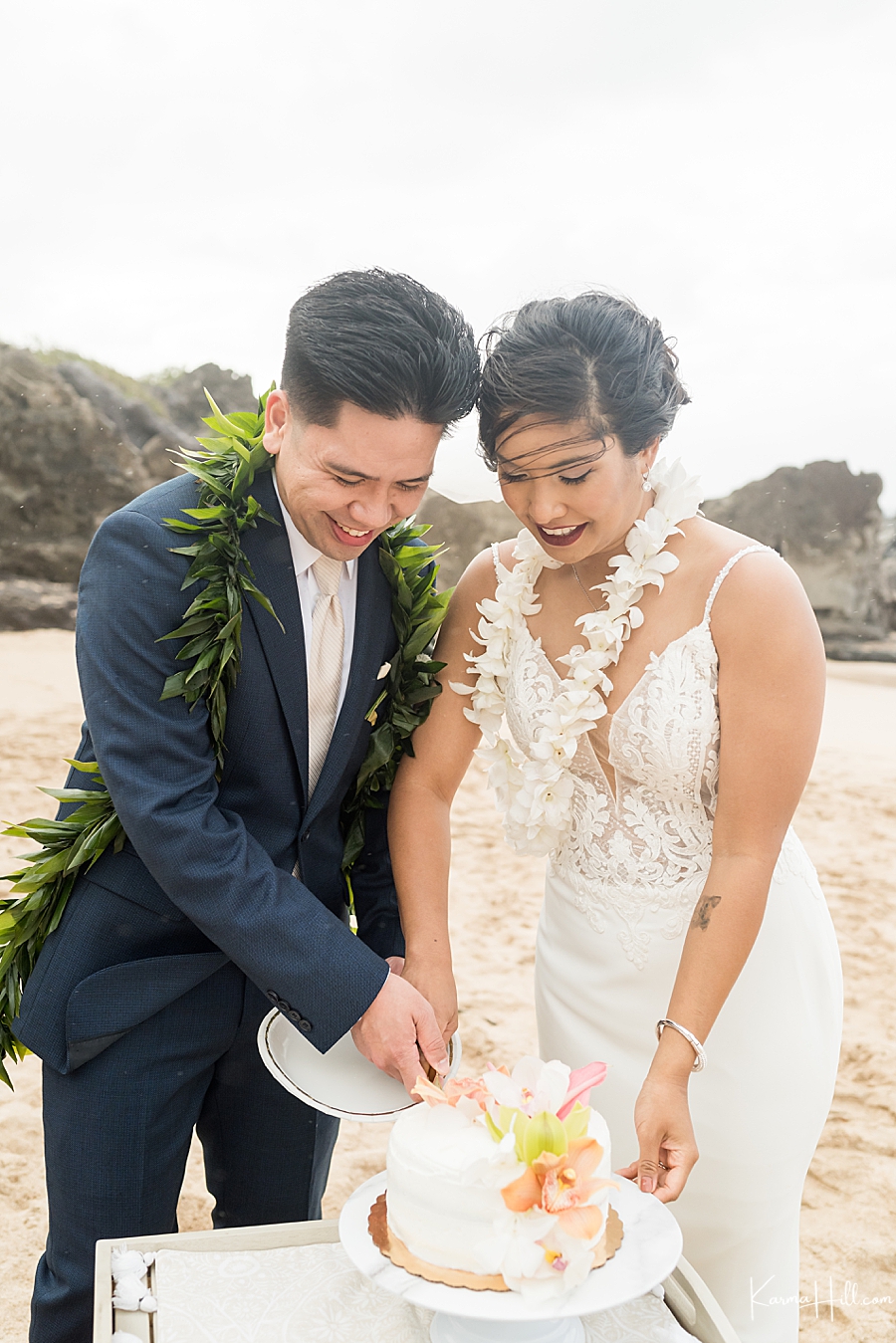 bride and groom cutting cake at beach wedding