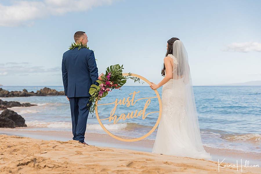 bride and groom with just mauid sign