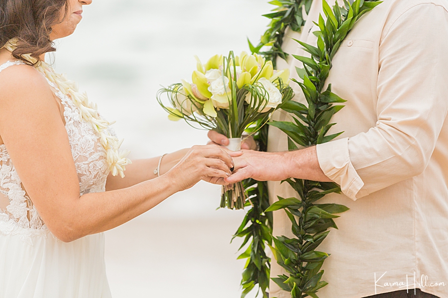 bride and groom exchange rings at maui wedding