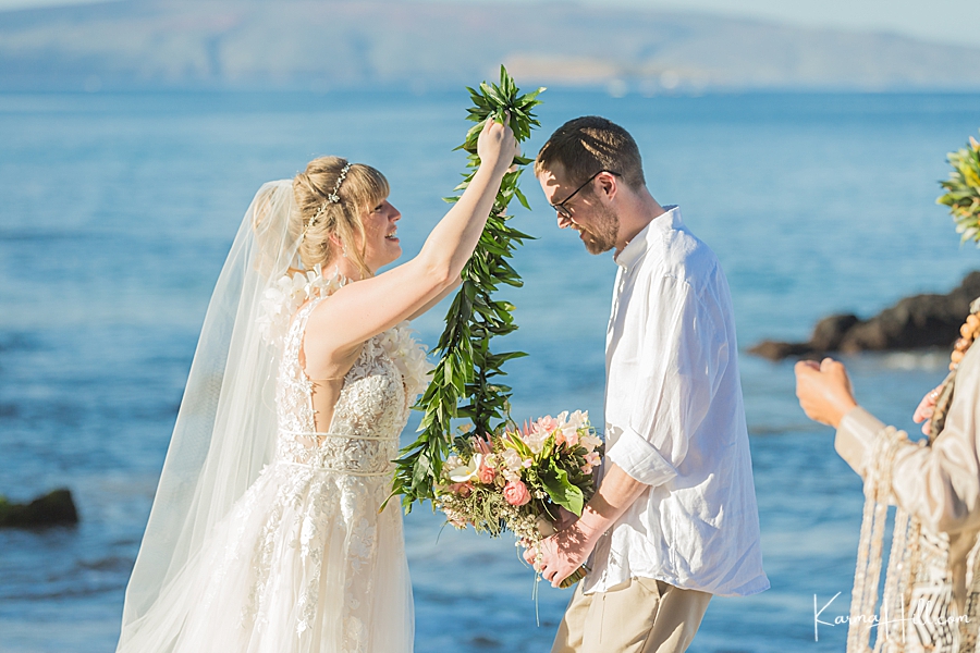 bride exchanging lei with groom at hawaii wedding