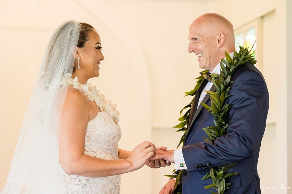 bride exchanging ring with groom at hawaii wedding