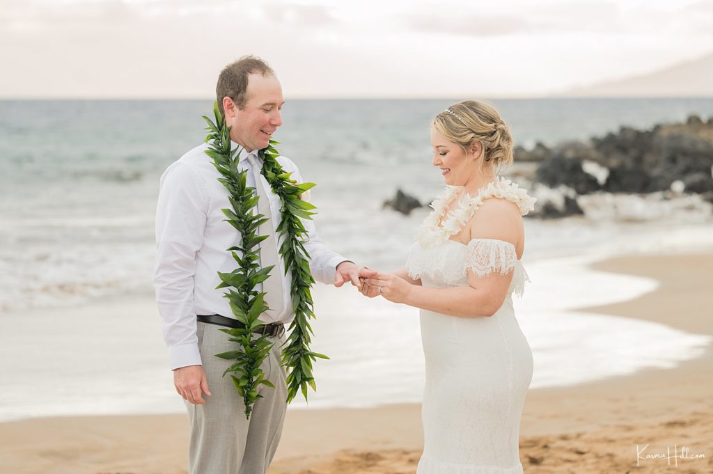 bride exchanging ring with groom at hawaii wedding